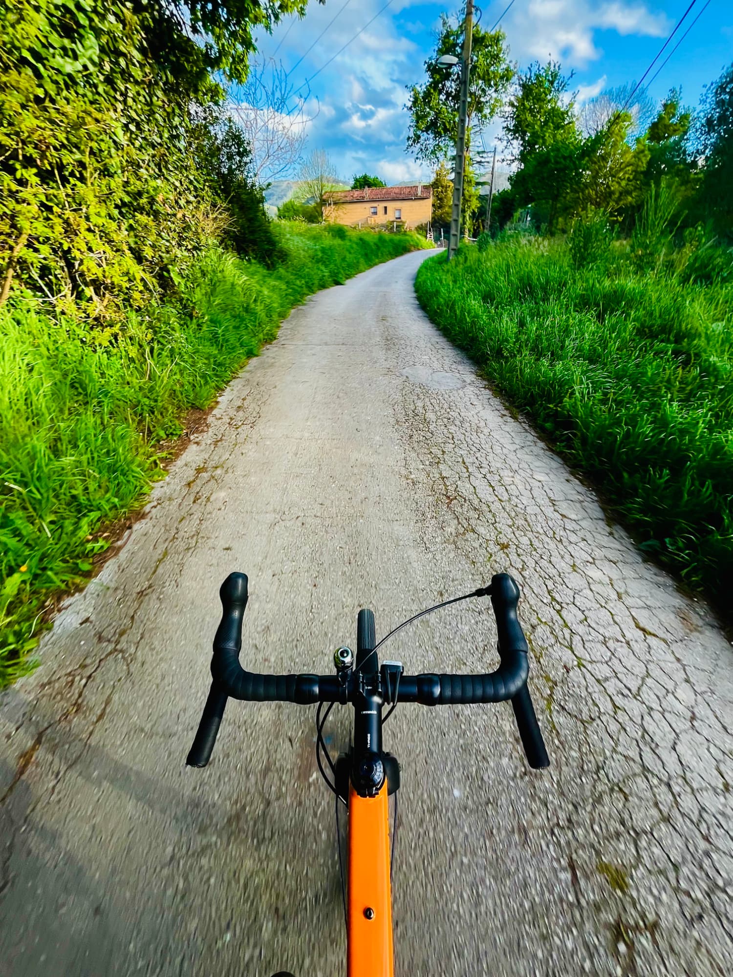 Un camino con una casa antigua al fondo.